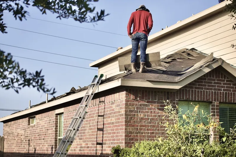 Professional roofer working on a residential roof in Creslo